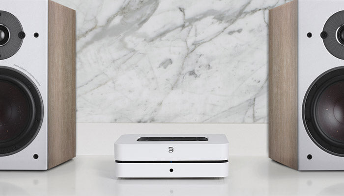 Bluesound Powernode white front on cabinet with speakers view