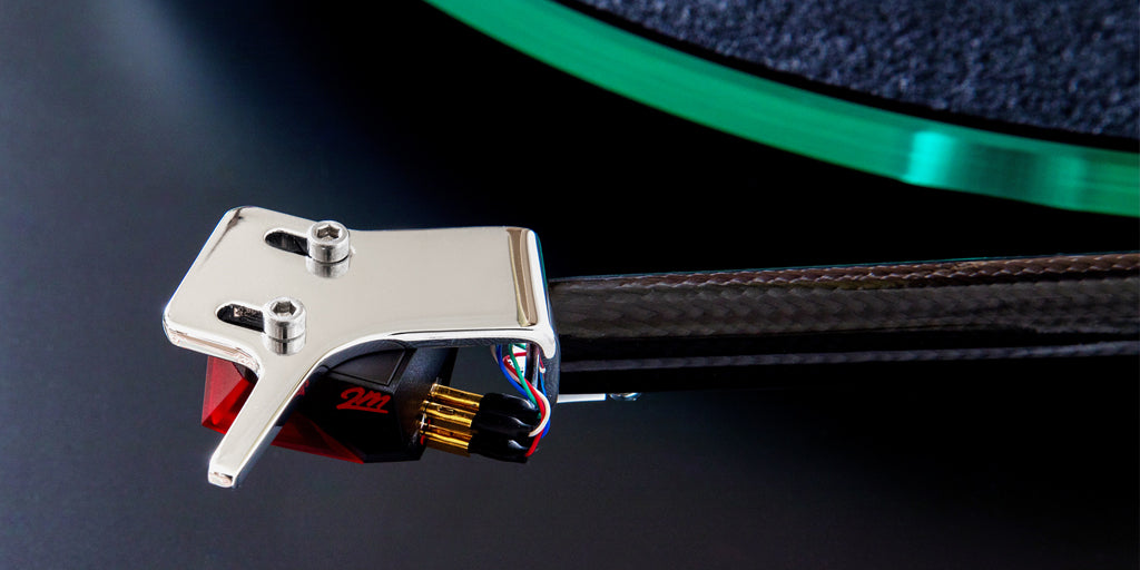 Close-up of a cartridge and tonearm over a vinyl record